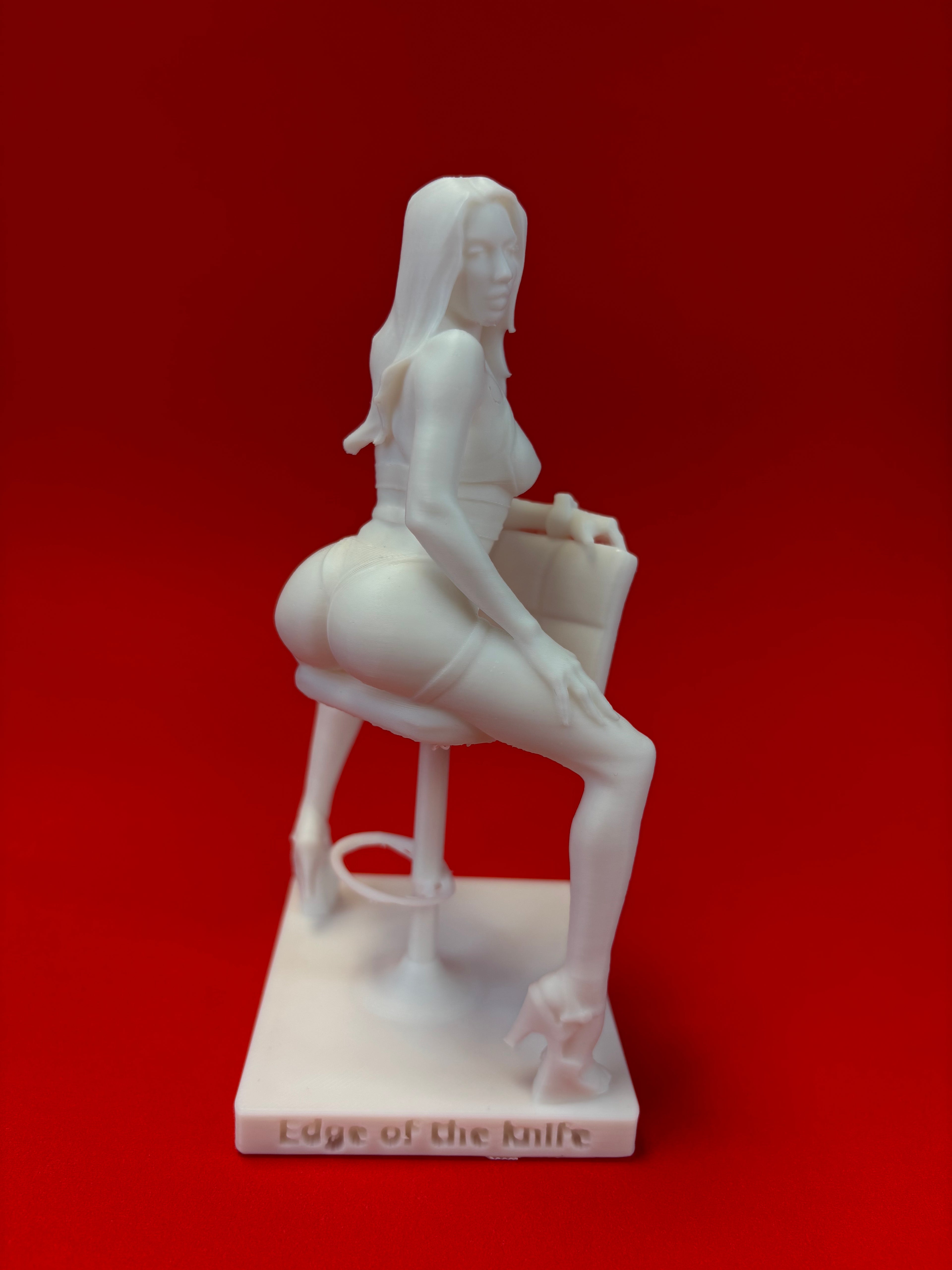 White sculpture of a figure on a red background