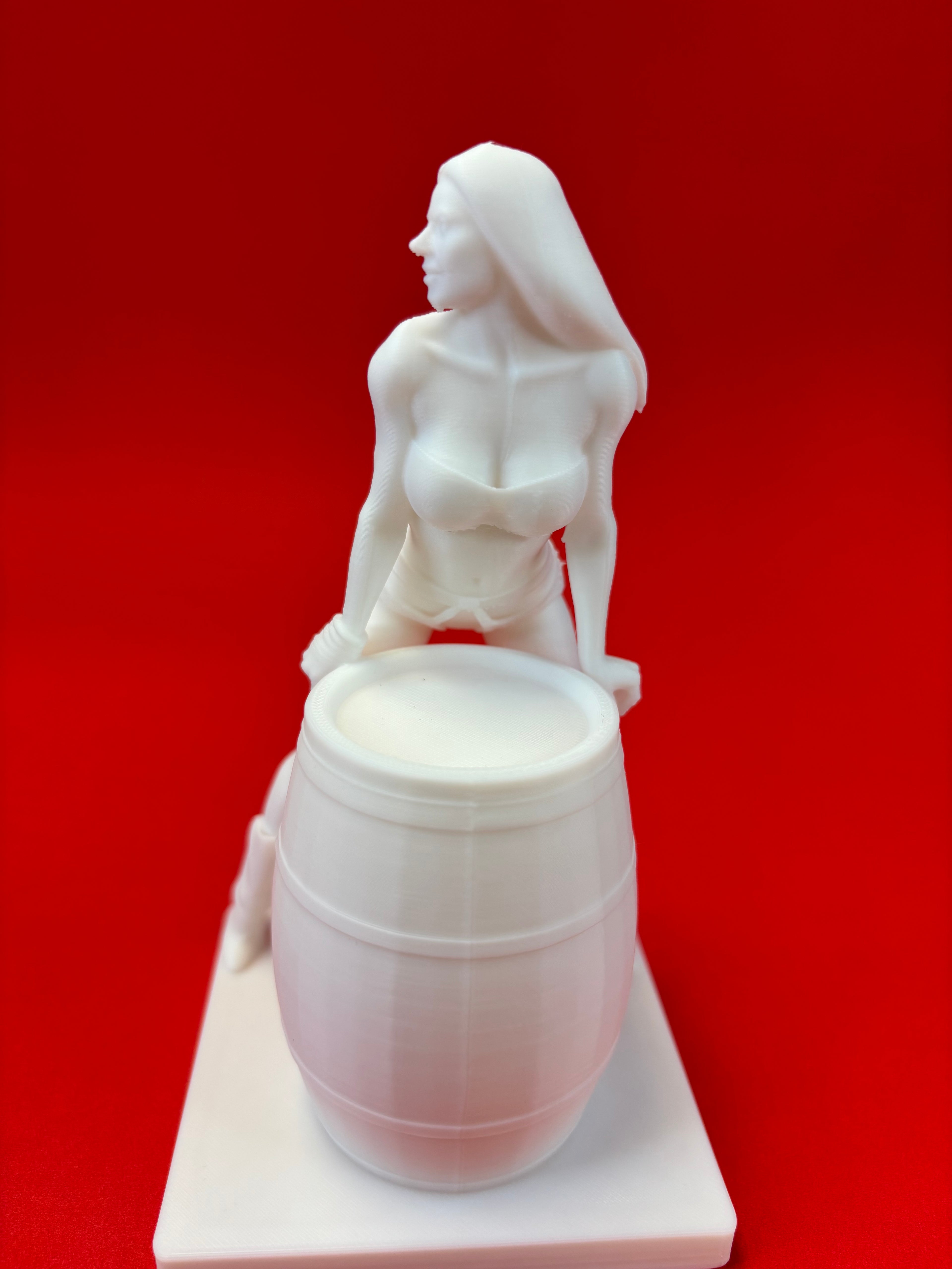White sculpture of a women with barrel  a red background
