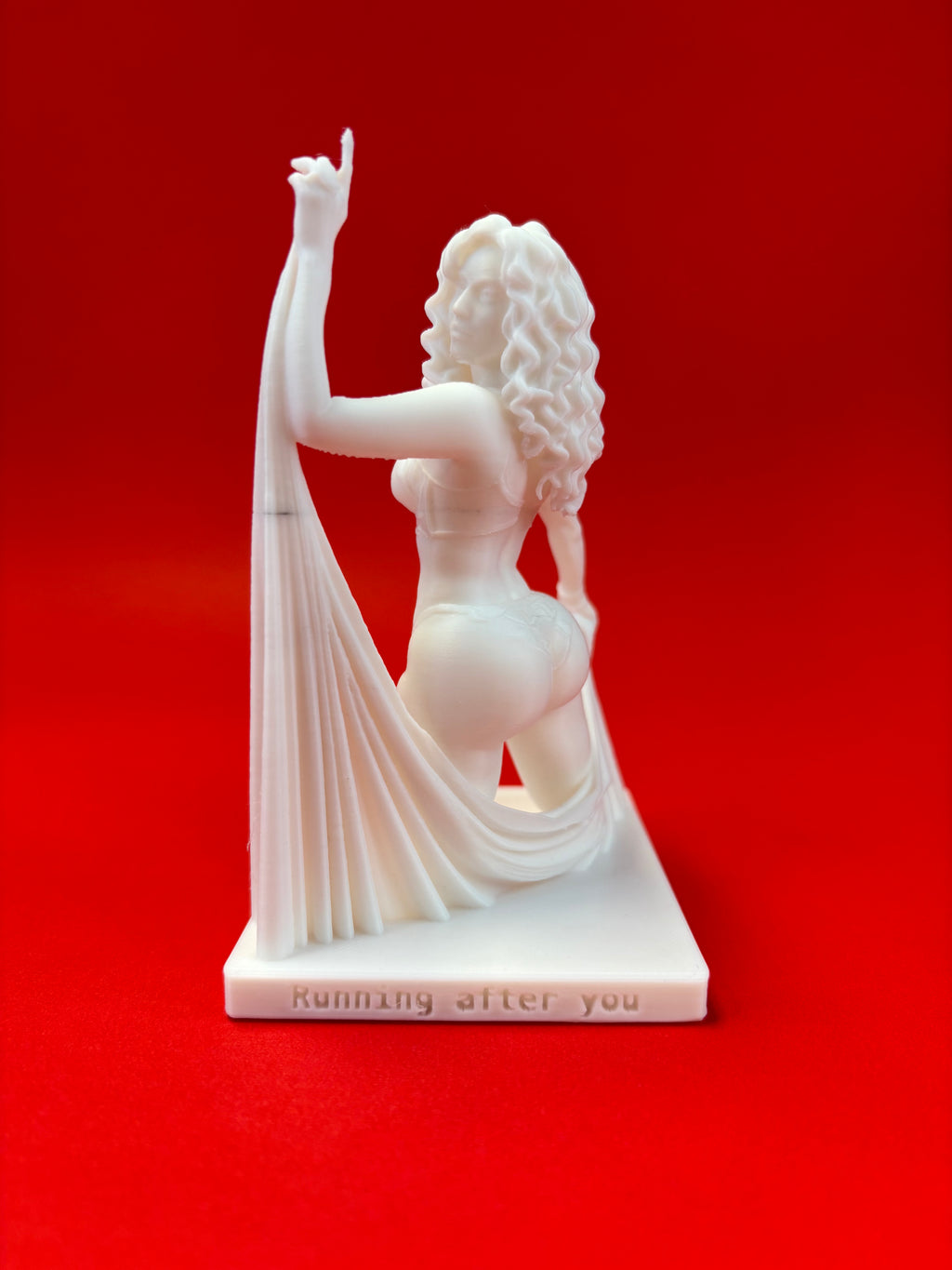 Statue of a woman with a drape on a red background
