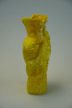 A bright yellow sculptural ceramic vase with a textured, hand-painted finish, standing on a neutral light gray background.