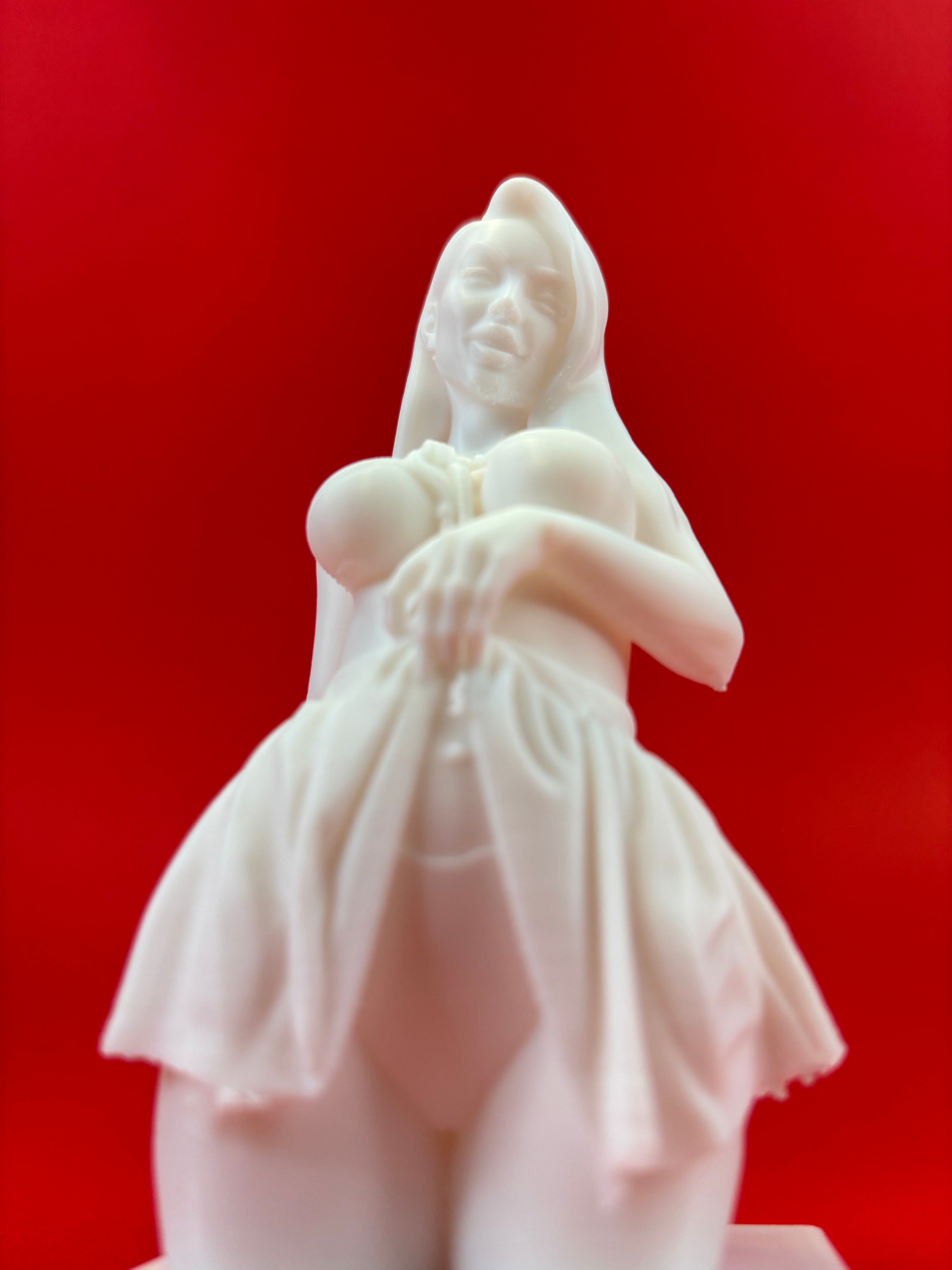 White figurine of a woman against a red background