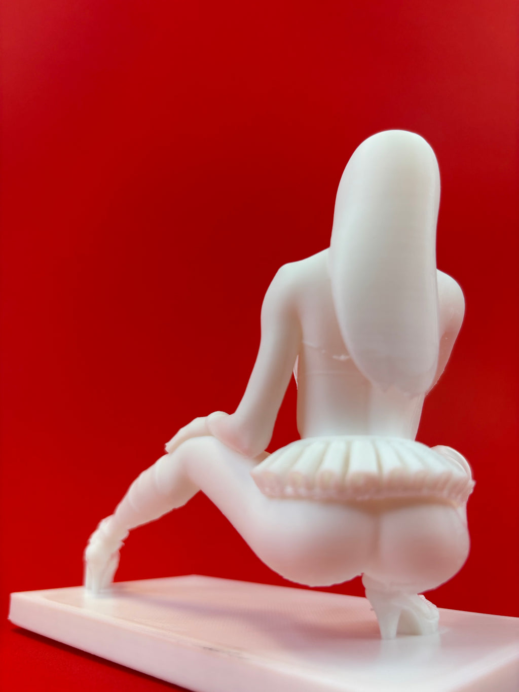 White model of a female on a red background