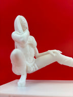 White ceramic sculpture of a figure on a red background