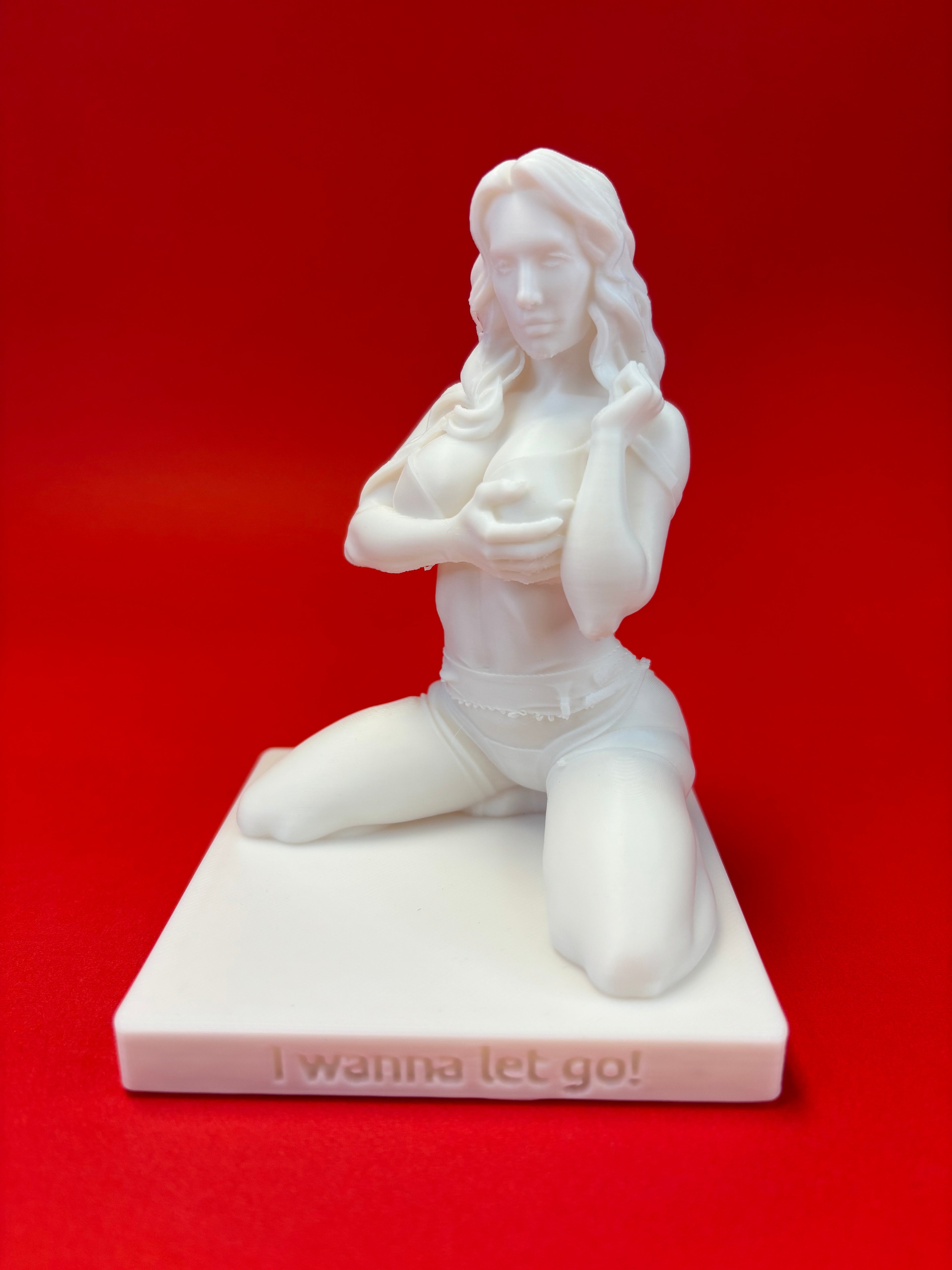White sculpture of a angelic figure on a red background