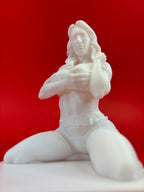 White sculpture of a woman holding a flower against a red background